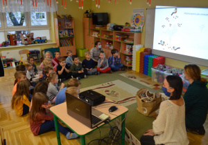 Dzieci z grupy III i IV oglądają prezentację dotyczącą dokarmiania ptaków
